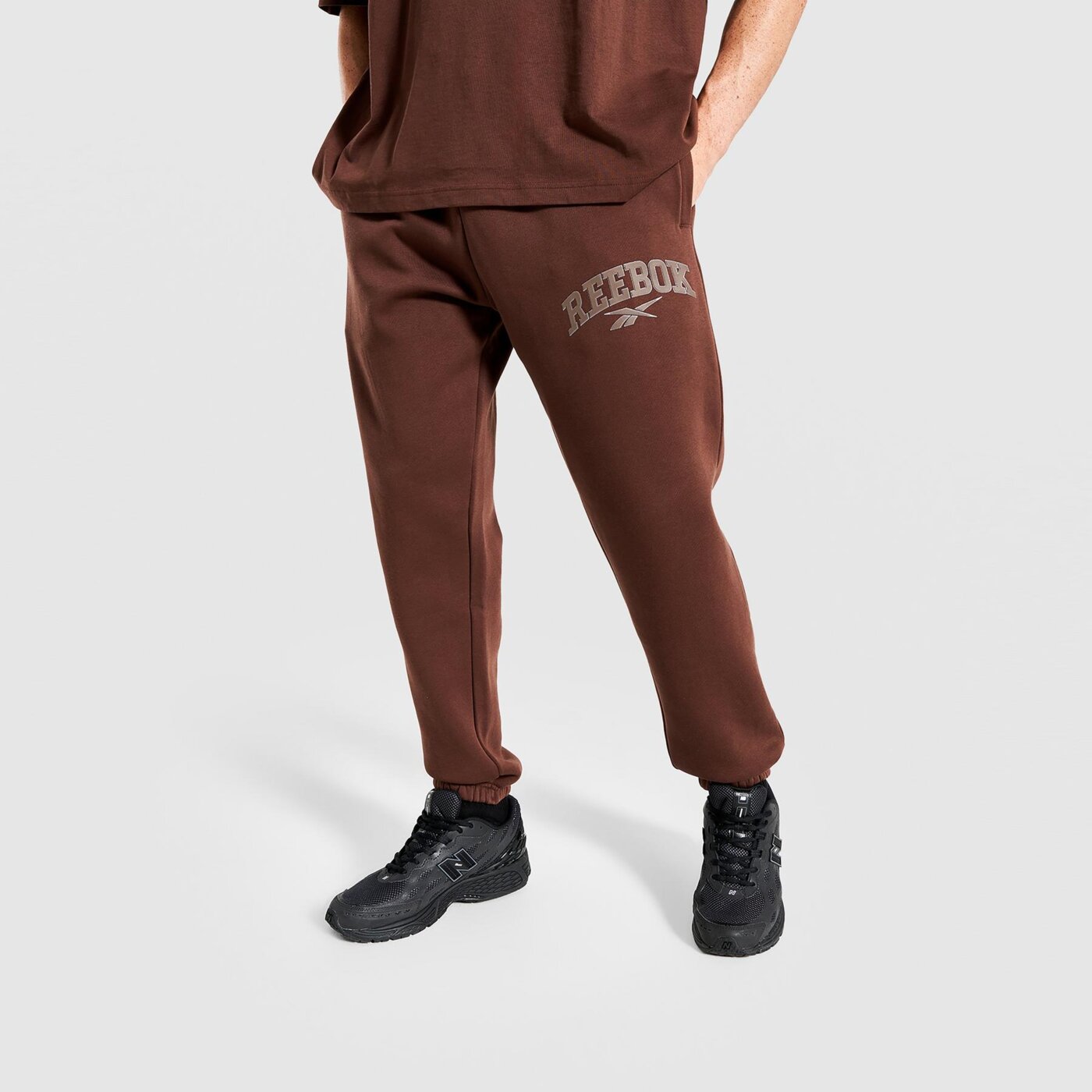 Spodnie dresowe męskie REEBOK SPODNIE PHILLIP VARSITY 100241203 kolor brązowy